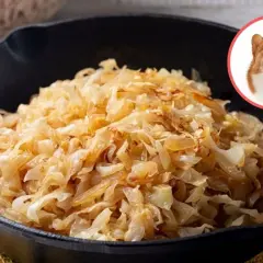 Czy pies może jeść kapustę kiszoną? Wesoły piesek z językiem na wierzchu spogląda na miskę pełną kapusty.