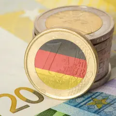 Monety euro z flagą Niemiec i banknot 20 euro. Zastanawiasz się, ile zarabia technik weterynarii w Niemczech?