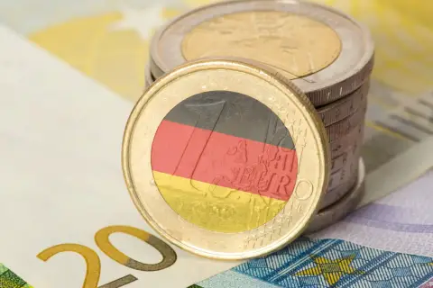 Monety euro z flagą Niemiec i banknot 20 euro. Zastanawiasz się, ile zarabia technik weterynarii w Niemczech?