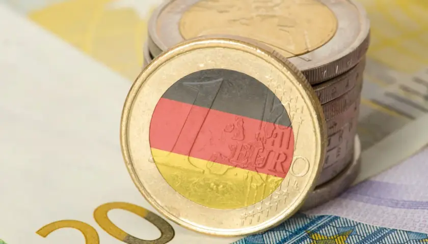 Monety euro z flagą Niemiec i banknot 20 euro. Zastanawiasz się, ile zarabia technik weterynarii w Niemczech?