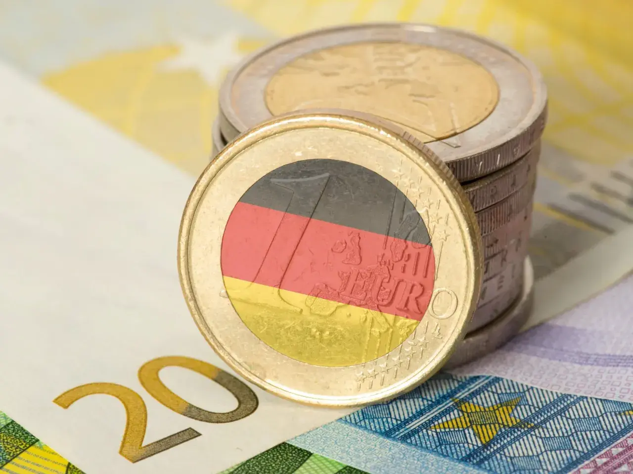 Monety euro z flagą Niemiec i banknot 20 euro. Zastanawiasz się, ile zarabia technik weterynarii w Niemczech?